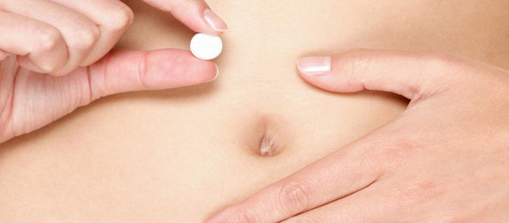 Frauenbauch Hand mit Pille zur Verhütung